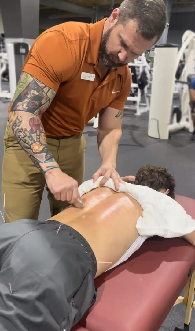 A man is getting his back examined by an instructor.